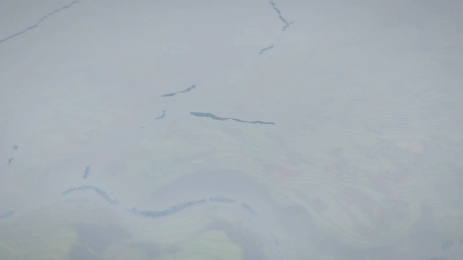 The valley in mist, ridgelines dissolving to white.